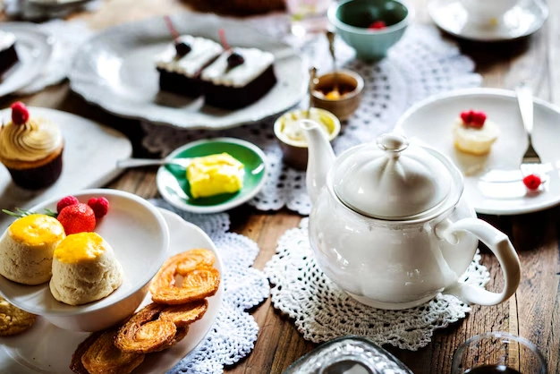 Teapot-and-variety-of-desserts-on-table-with-scones-and-cakes